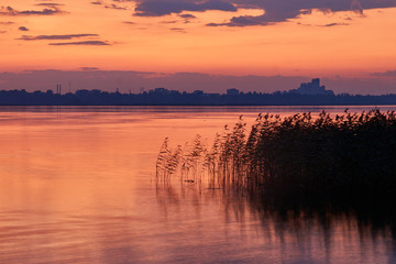 lake and city on the background of a colorful sunset