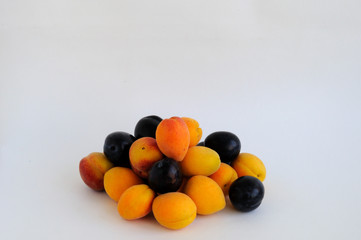 Fruits of apricot, plum and peach on a white background.
