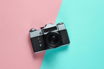 Vintage retro style film camera on pink blue pastel background. Top view