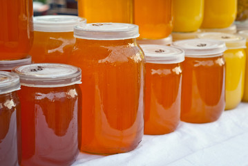 Lots of assorted honey on the table. Jars of sweets are sold at the fair.