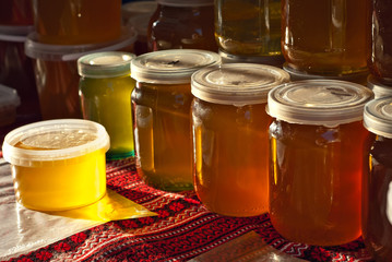Lots of assorted honey on the table. Jars of sweets are sold at the fair.