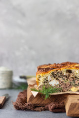 Pie with liver, egg and dill filling on a wooden cutting board. Healthy nutrition lunch or dinner.