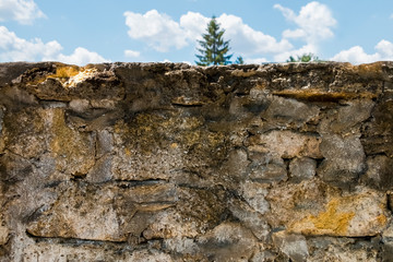 Old dilapidated stone wall of the park.