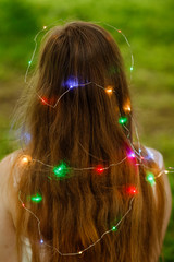 Fashion, pop art. Playful woman with garland fairy lights outdoors at night, vintage style.brunette woman. hipster girl dancing in colorful lights. stylish hair.sparkling multi-colored garland
