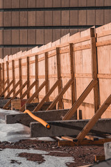 Wooden fence that surrounds the construction site on a spring day