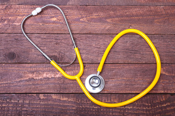 Medical stethoscope and tablets isolated on wooden background