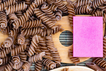 raw pasta with wooden spoons and marker for writing