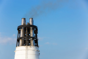 Smoke from a ferry liner pipe against a blue sky close-up