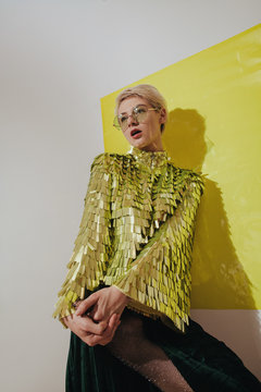 Woman wearing shiny golden shirt and glasses