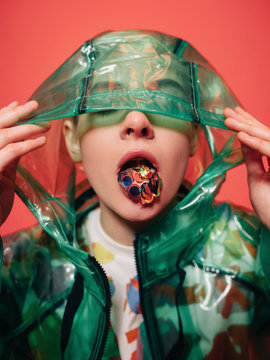 Young person in raincoat showing tongue with colourful confetti