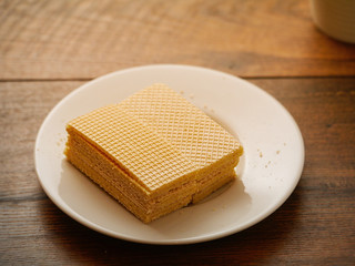 Stack of waffles on a white plate, Warm colors, selective focus. Wooden table.