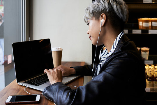 Grey-haired asian with laptop.