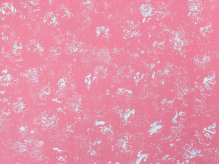 Abstract pastel pink background with white spots. Chaotic spots of white dye on the painted with a pink color surface. Acrylic paints.