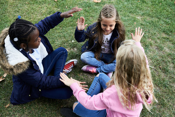 Kids playing hand-clapping game.