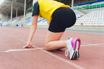 Cropped shot of young female athlete launching off the start line in a race. Female runner started...