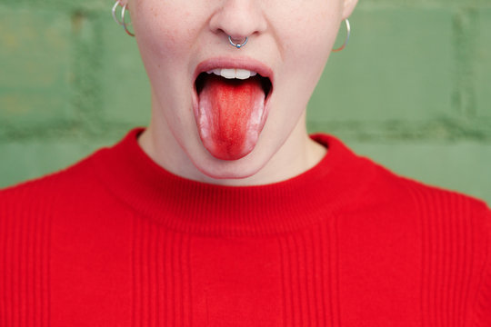 Playful girl showing tongue with red tongue.