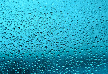 Water drops on glass, green background