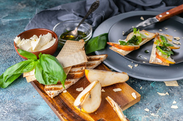 Close-up Biscuits with cream cheese and pear slices. Hot sauce with garlic and basil. Horizontal shot