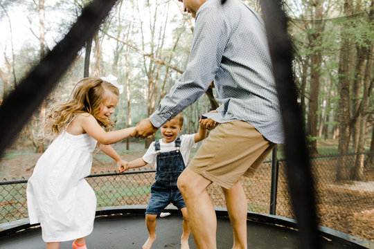 Dad Jumping on Trampoline with Kids