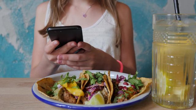 Teenager cute girl in mexican restaurant take smartphone picture food photo for social media having fun before eating