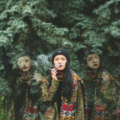 Drama surrounded by the ghosts of smoking girl twins on a background of trees. Production of the...