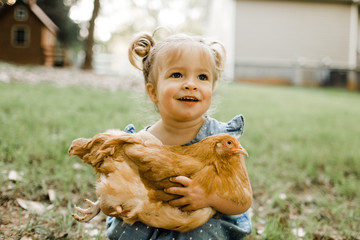 Little girl holding chicken