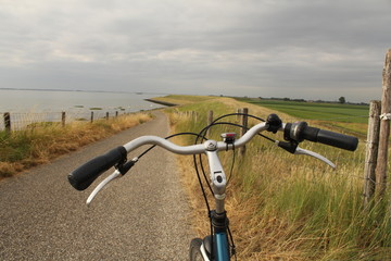 Fototapeta na wymiar a bicycle handlebar at a road on top of the seawall along the western scheldt sea at the dutch coast