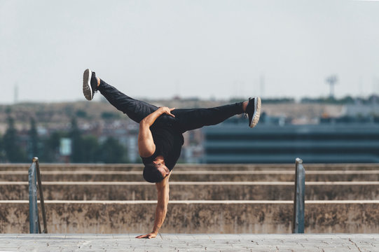 Young hispanic latin break dancer performing a dance pose in urban scenery