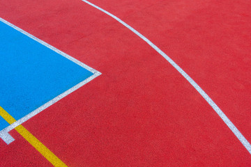 Fototapeta na wymiar Colorful sports court background. Top view to red and blue field rubber ground with white and yellow lines outdoors