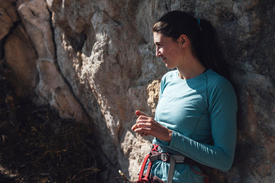 Young woman climber looking at horlizon leaning on the rock