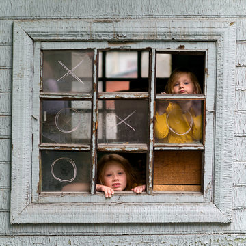 Little girls in window of old house