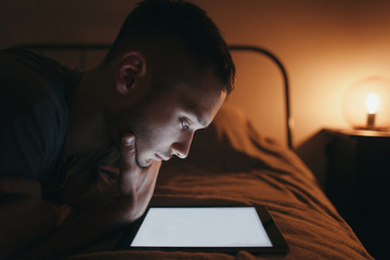 Teenager reading electronic book in cozy room