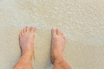 men's feet on sand