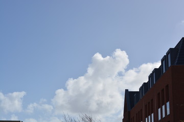 blue sky and clouds with a roof house on the side