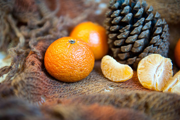 mandarin, mandarin slices and a knob on a knitted plaid. New Year's decoration