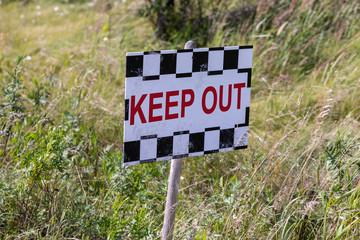 Keep out sign in the grass lolly close up