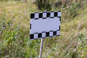 Blank sign in the grass lolly close up