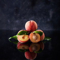 Fototapeta na wymiar Fresh peaches on dark background