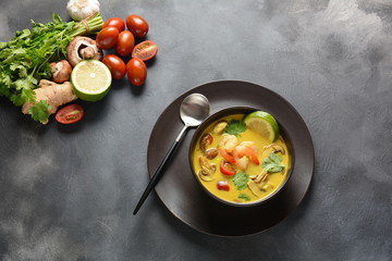 Tom Yam kung Spicy Thai soup with shrimp, seafood,tomatoes, mushrooms, lemongrass, coconut milk, ginger and chili pepper in bowl . Traditional Thai food