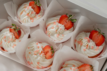cupcakes decorated with cream and strawberries