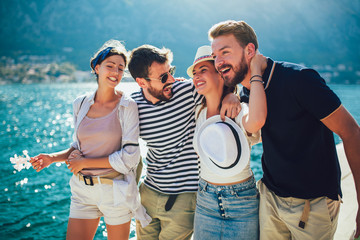 Happy group of tourists traveling and sightseeing together near the sea