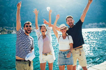 Happy group of tourists traveling and sightseeing together near the sea