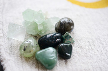 Lush green crystal collection, Green Quartz, Malachite, Peridot, Fluorite, rainforest jasper, and Quantum Quattro. Prosperity and abundance healing crystal collection. White background, bright colors