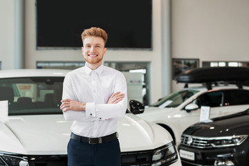 Salesman in modern car showroom