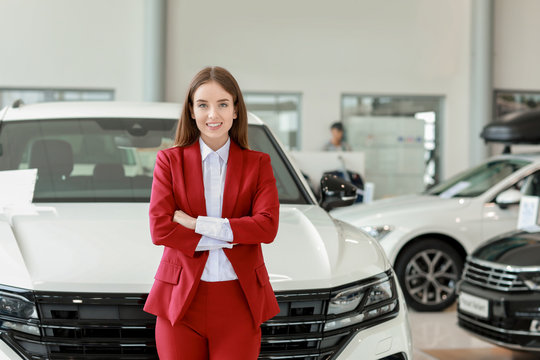 Saleswoman in modern car showroom