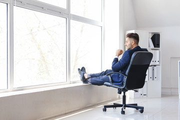 Carefree businessman having break in office