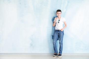 Fototapeta na wymiar Stylish boy in jeans clothes near color wall
