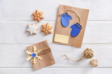 Christmas greeting cards with cookies on white wooden background