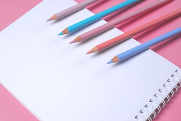 white notebook with pastel pencils