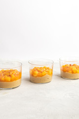 Caramel panna cotta, custard pudding with peach and passion fruit, white table, copy space